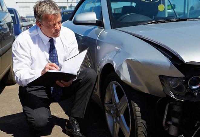 car insurance claim form with a pen and calculator